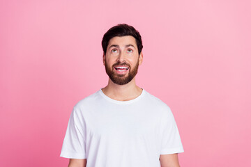 Obraz premium Photo portrait of handsome young guy look up interested empty space dressed stylish white garment isolated on pink color background