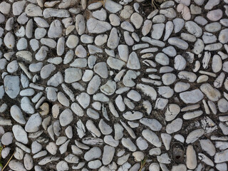 A collection of white stones placed on the ground and used for foot massage