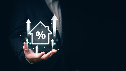 Businessperson with a holographic projection of a house and percentage symbol, concept of real estate investment and mortgage rates.