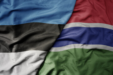 big waving national colorful flag of gambia and national flag of estonia.