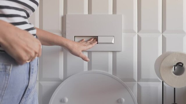 A woman flushes the toilet. Frequent toilet visits due to symptoms of diseases such as urinary tract infections, urethritis, cystitis or pyelonephritis in women. Women's health.