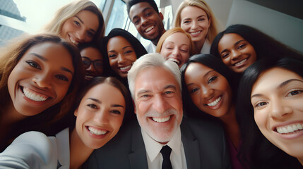 Happy diverse team having fun together. Low angle group portrait of cheerful joyful young and senior Caucasian and African American business people friends huddling, looking down at camera and smiling