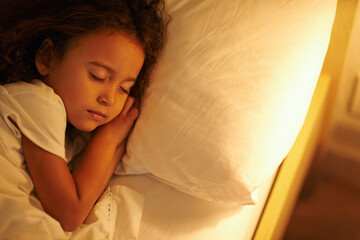 Child, sleeping and peace in bed at night, comfortable and tired or dream on pillow in home. Female...