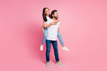 Full length photo of lovely young couple hold piggyback look empty space dressed stylish white garment isolated on pink color background