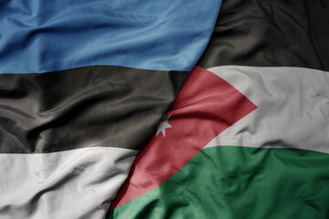 big waving national colorful flag of jordan and national flag of estonia.