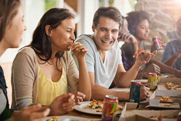 Friends, laughing and eating of pizza in home with happiness, soda and social gathering for bonding in dining room. Men, women and fast food with funny joke and diversity at table in lounge of house