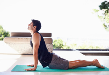 Yoga, fitness and breathing with man in cobra pose for self care, aura and balance in workout at...