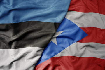 big waving national colorful flag of puerto rico and national flag of estonia.