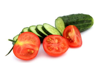 Sliced fresh cucumbers and tomatoes lie on a white background	