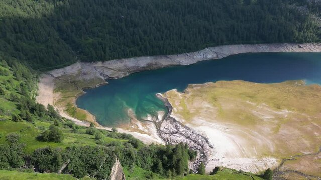 Drone view of the scenery landscape of Lake Ritom in Switzerland surrounded by green dense trees