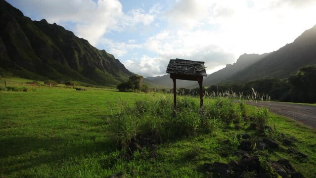 Wide, steady cam circling ancient well in Hawaiian valley - sunset
