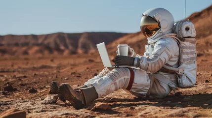 Deurstickers A space-suited astronaut relaxes with a laptop and coffee amidst a rocky, Mars-reminiscent environment © Fxquadro