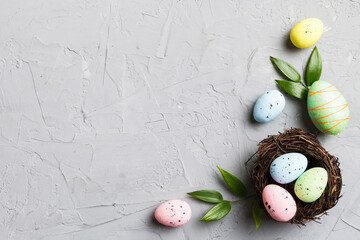 Colorful easter eggs in nest on table background with copy space top view