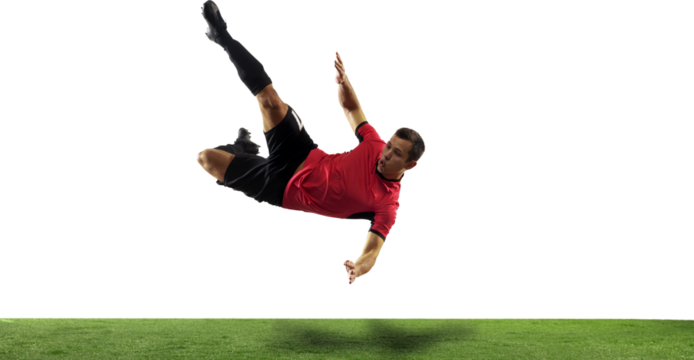 Competitive young man, soccer playing in motion during game, falling down, hitting ball isolated on transparent background with grass flooring. Concept of sport, game, competition, active lifestyle