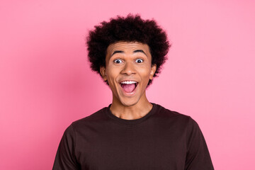 Portrait of young amazed wavy chevelure hair funny man in brown t shirt open mouth impressed reaction isolated on pink color background - obrazy, fototapety, plakaty