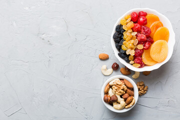 healthy snack: mixed nuts and dried fruits in bowl on table background, almond, pineapple, cranberry, cherry, apricot, cashew