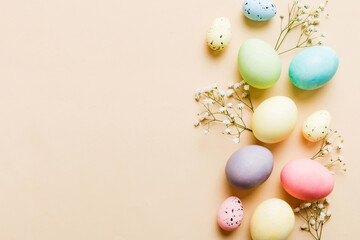 Happy Easter composition. Easter eggs on colored table with gypsophila. Natural dyed colorful eggs background top view with copy space
