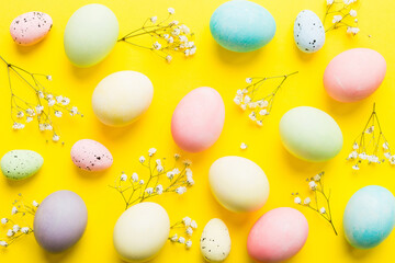 Happy Easter composition. Easter eggs on colored table with gypsophila. Natural dyed colorful eggs...