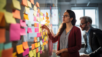 A professional team engaged in a brainstorming session, using colorful sticky notes on a glass wall to organize their ideas and strategies.