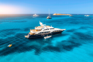 Aerial view of luxury yacht on blue sea at sunset in summer. Sardinia, Italy. Aerial view of speed...