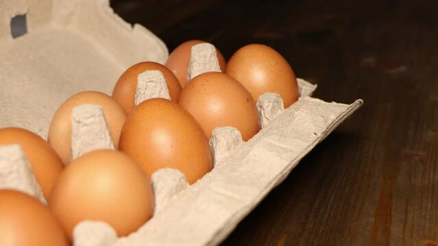 eggs in a biodegradable cardboard box on the kitchen table. Fresh chicken eggs slow motion