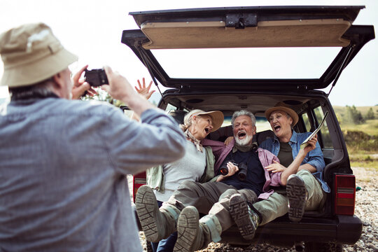 Seniors taking photos and laughing on a car trip