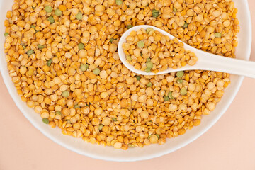 Pea yellow groats grains cereal in spoon close-up macro.