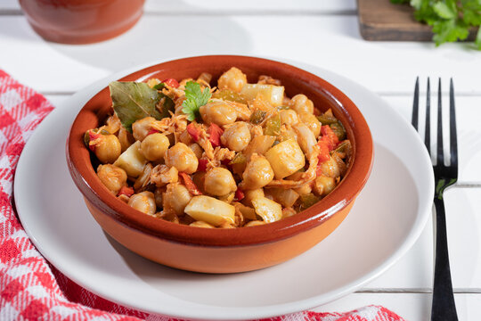 Close up. Ropa vieja, typical Canarian dish of chickpeas stew on earthenware casserole on white table.