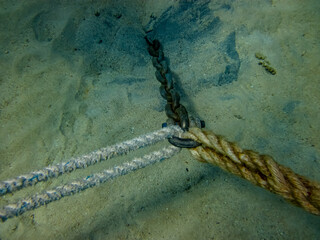 Anchor on the seabed secured with ropes