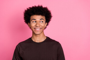 Obraz na płótnie Canvas Portrait of cheerful happy young guy in brown t shirt looking empty space discount information advert isolated on pink color background