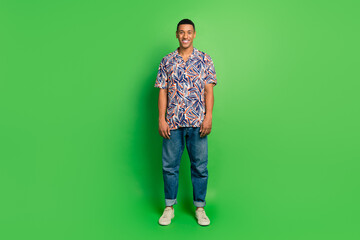 Fototapeta premium Full length photo of attractive cheerful man standing in stylish collection outfit isolated on green color background