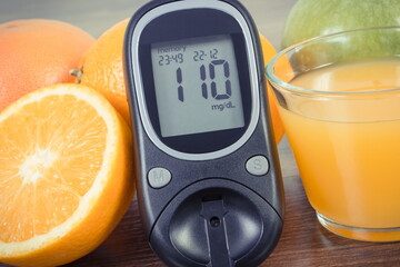 Glucose meter for checking sugar level, fresh fruits and orange juice. Healthy lifestyle and...