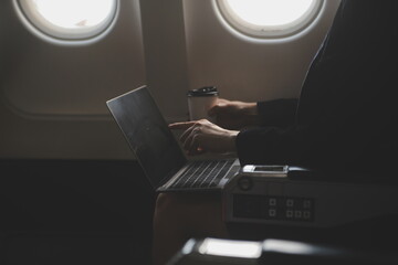 Blonde female tourist checking incoming notification on smartphone sitting on seat of airplane with...