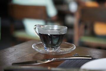 Blue tea is served in a nice glass cup at the breakfast table.           