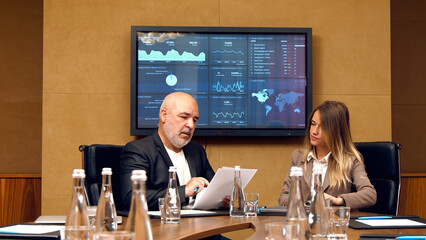 Two business partners a beautiful young woman and a man in business suits make a deal. Reaching an agreement at a negotiation meeting. Partnership of business people.