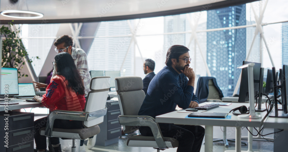 Leinwandbilder Young Team of Indian Specialists Working on Computers and Having a Conversation in the Office. Male and Female Colleagues Discussing a Solution for Their Generative Artificial Intelligence Project