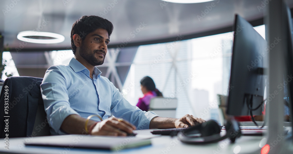 Aufkleber Portrait of a South Asian Financial Securities Trader Working on Desktop Computer in a Modern Office. Handsome Indian Accountant Bookkeeping Financial Affairs of a Business Venture