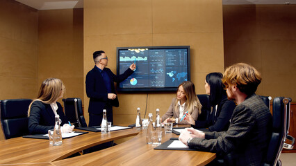 A diverse multinational team of professional business people meet in the conference room of a...
