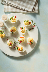 Deviled eggs on ligh blue background with sunligh and harsh shadows, directly above - 753146934