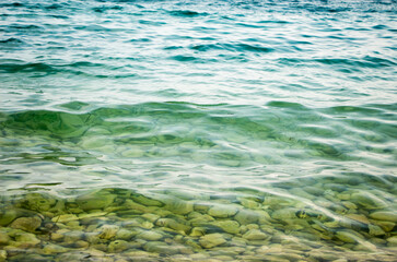 Stones in the sea near the shore under clear water