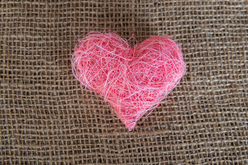 Pink fabric heart shape on the natural background.