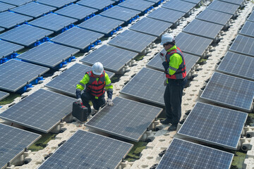 Photovoltaic engineers work on floating photovoltaics. workers Inspect and repair the solar panel equipment floating on water. Engineer working setup Floating solar panels Platform system on the lake.