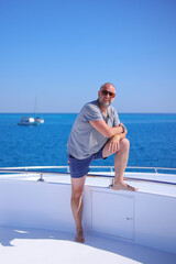 guy businessman in shorts and glasses on a white yacht in the red sea