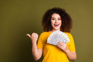 Photo of amazed young curly hair woman wear yellow t shirt point finger billboard extra salary...