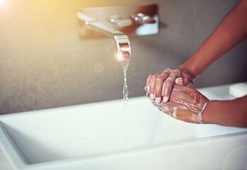 Washing hands, bathroom and person with water in home with soap for hygiene, bacteria or germs in...