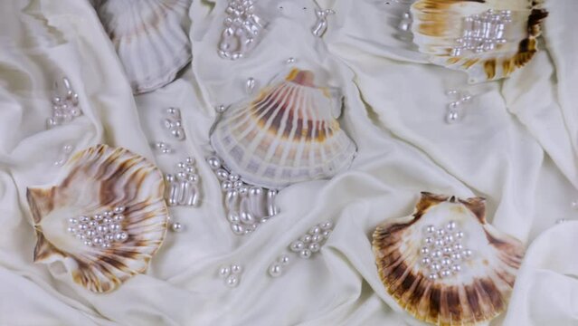 Ripples on the surface of the water against the background of seashells with pearls underwater.