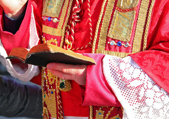 Religious Pastor in Red Vestments Blessing with Bible