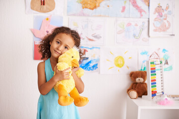 Girl, portrait and cute with duck to cuddle in bedroom for comfort or playtime, smile and innocent....