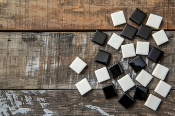 Black and white gaming pieces scattered on wooden background.