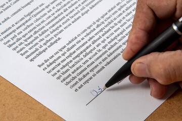 printed document signature showing a hand and ballpoint pen.